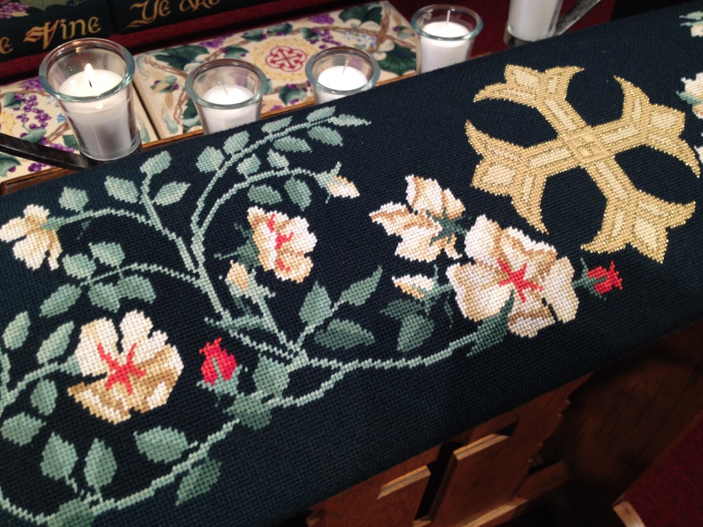 Roses and cross, in needlepoint.